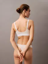 Corpiño Calvin Klein color beige, de breteles anchos y corte deportivo. Elástico con logo de la marca en el contorno inferior.