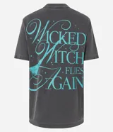 Remera de algodón gris oscuro con efecto desteñido y estampado frontal de Elphaba, la Bruja Mala del Oeste, con el texto "FEEL WICKED ELPHABA".