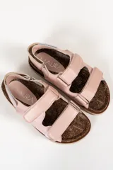 Sandalias bajas de cuero color rosa claro, con suela de corcho y ajuste con velcro.