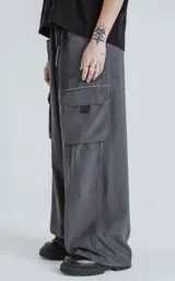 Pantalón cargo gris grafito de corte ancho, con cintura elástica ajustable con hebilla y múltiples bolsillos.