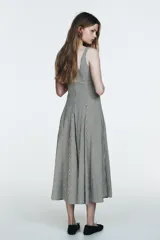 Vestido midi de tirantes con escote cuadrado y falda amplia con godets, confeccionado en tela con estampado de cuadros vichy en blanco y negro.