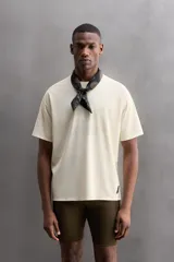 Camiseta deportiva marrón con estructura perforada, cuello redondo, manga corta y logo estampado.