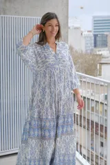 Vestido largo celeste y blanco con estampado geométrico, escote en V y mangas 3/4.