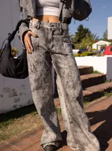 Jean de mujer color gris con efecto acid wash, de tiro alto y corte recto. Presenta costuras verticales en la parte delantera y bolsillos laterales.