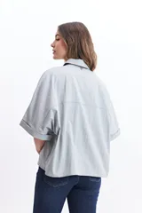 Camisa color beige de corte oversize y manga corta.