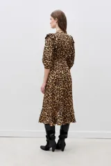 Vestido midi con estampado animal print de leopardo, escote en V cruzado, mangas 3/4 con volados en los hombros, cinturón negro con aplique de flor y volados en el ruedo.