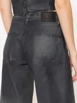 Pantalón de jean de corte recto y tiro medio-bajo, confeccionado en denim 100% algodón con proceso de coating simil cuero en tono azulado. Presenta desgastes estratégicos que dejan ver la base natural.