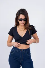 Remera corta color beige con escote en V y nudo frontal.