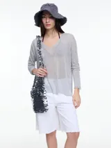 Sweater liviano manga larga confeccionado en hilado con lurex. De calce holgado, escote en V y aberturas laterales.