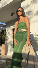 Corset verde de rafia con flecos y cinturón con apliques metálicos.