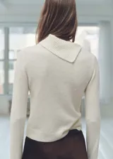 Sweater color beige de tejido de punto, con cuello solapa alto y mangas largas.