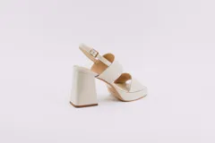 Sandalias de plataforma color borgoña, confeccionadas en charol. Tienen dos tiras anchas sobre el empeine, pulsera con hebilla al tobillo y taco cuadrado de 9 cm.