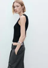 Top negro de punto medio con cuello escotado y sisas con terminación acanalada.