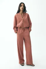 Pantalón de tiro alto color ladrillo, con cintura elástica ajustable, bolsillos delanteros y traseros. Corte ancho.