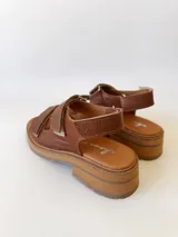 Sandalias de cuero color camel con plataforma y doble tira ancha con hebilla.