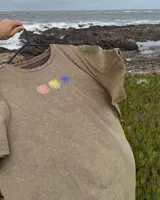 Remera color arena de manga corta con tres flores estampadas en el pecho.