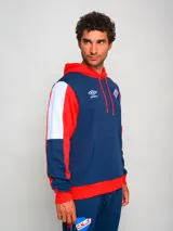 Hoodie deportivo multicolor con capucha, cordones rojos, bolsillo tipo canguro y puños y cintura acanalados. Presenta el logo de Umbro bordado en el pecho y el escudo del Club Nacional de Football estampado en el pecho y en el pantalón.