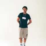 Short color beige con cintura elastizada y cordón ajustable. Cuenta con bolsillos laterales y bolsillos cargo con diseño gráfico de una casa con calavera.