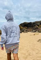 Canguro gris con capucha y estampado en la espalda de una ola y un sol dentro de un recuadro.
