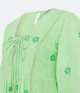 Vestido corto color verde lima con estampado de flores en verde claro, escote en V con lazo, mangas 3/4 con puños elásticos y falda con volantes.