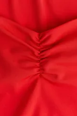 Top corto sin mangas color rojo, de punto suave y ajuste ceñido. Presenta escote corazón profundo y costura fruncida en el centro del busto.