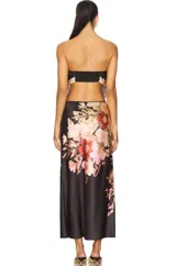 Conjunto de top bandeau y falda larga con estampado floral en tonos negro, rosa y beige. El top es strapless y la falda tiene corte a la cadera con abertura lateral.