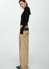 Buzo negro de tejido de punto fino, con cuello redondo y mangas largas.
