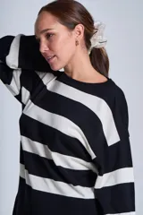 Sweater Bremer con cuello redondo y mangas largas ligeramente amplias. Diseño a rayas horizontales en color crudo y negro.