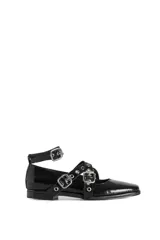 Chatas de cuero color negro con tiras cruzadas y tachas plateadas.