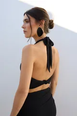 Top corto azul con brillos, escote halter y espalda descubierta.