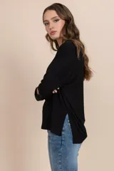 Remera negra de tejido rib con cuello redondo y mangas largas.