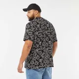 Camiseta negra de manga corta con cuello redondo y estampado de figuras de Keith Haring en color blanco.