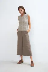 Chaleco tejido marrón con escote en v y sisas amplias. Diseño con diferentes puntos combinados en el frente.