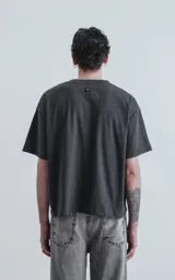 Remera manga corta gris oscuro, de cuello redondo y calce boxy fit.