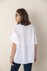 Blusa italiana de lino color blanco, de corte suelto con detalle de calado en hombros y mangas.
