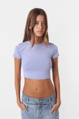 Top corto color celeste, tipo baby tee, al cuerpo, con mangas cortas y cuello redondo.
