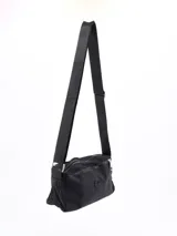 Bandolera negra de tela impermeable con correa larga regulable y cierre superior con doble cremallera.