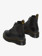 Botas Dr. Martens modelo Sinclair, color negro con textura granulada, plataforma Quad, cierre frontal con cremallera y cordones.