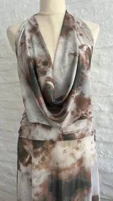 Vestido largo de microtul con estampado tie-dye en tonos rosa, verde y gris. Diseño con escote halter y espalda descubierta.