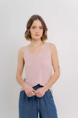 Musculosa tejida color rosado con hilo brillante, escote en V delantero y trasero, de textura liviana y calce relajado.