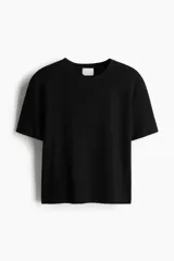Remera negra de punto fino, con cuello redondo y mangas cortas.