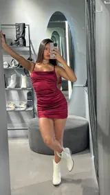 Minivestido de satén color bordó, con breteles finos y corte ajustado.