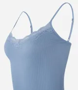 Blusa de pijama blanca de bretel fino con encaje en el escote y textura acanalada.