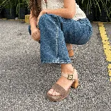 Sandalias de cuero color marrón con plataforma de madera y hebilla dorada.