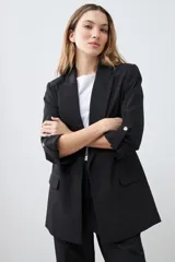 Blazer color crudo de corte recto, con cuello solapa, mangas 3/4 con botón y bolsillos frontales.
