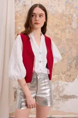 Chaleco rojo de cuero vacuno con corte sastrero y lazos de ajuste frontales.