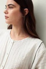 Camisa blanca a rayas grises, de lino, con cuello mao, mangas largas abullonadas y bordados en las sisas.