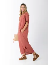 Vestido largo color ladrillo, de lino, corte amplio, mangas cortas, cuello bote y bolsillos laterales.