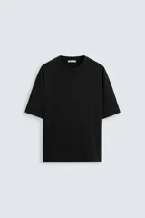 Camiseta negra relaxed fit confeccionada en algodón compacto, con cuello redondo y manga corta.