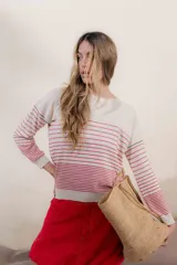 Sweater de punto color crema con rayas horizontales rojas y detalles en negro en los hombros.